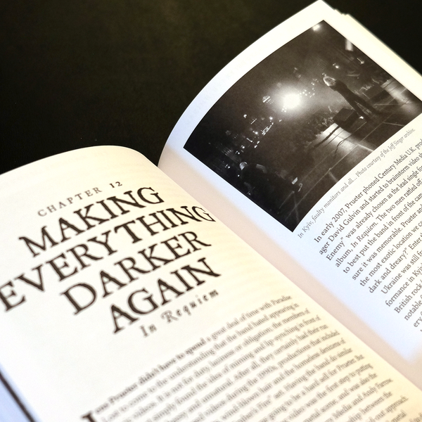 Open book with text and black and white photo on a dark background