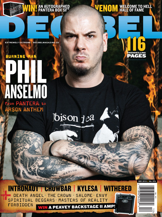 A cover of a magazine featuring a person with tattoos, wearing a black t-shirt, against a backdrop with a flame design. The magazine title is 'DECIBEL' and it has the subtitle 'Phil Anselmo'.